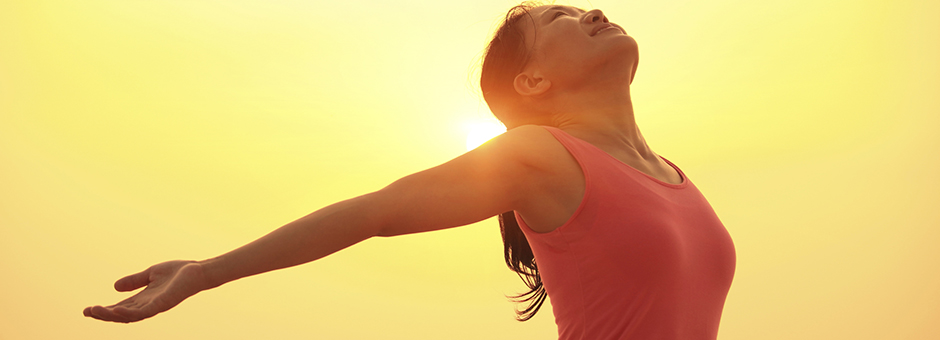 Woman celebrating her health at the dawn of a new day, thanks to The Center For Ultra Health.